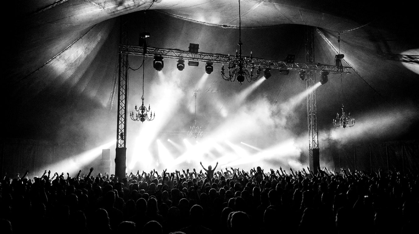 Light beams over a concert crowd in silhouette